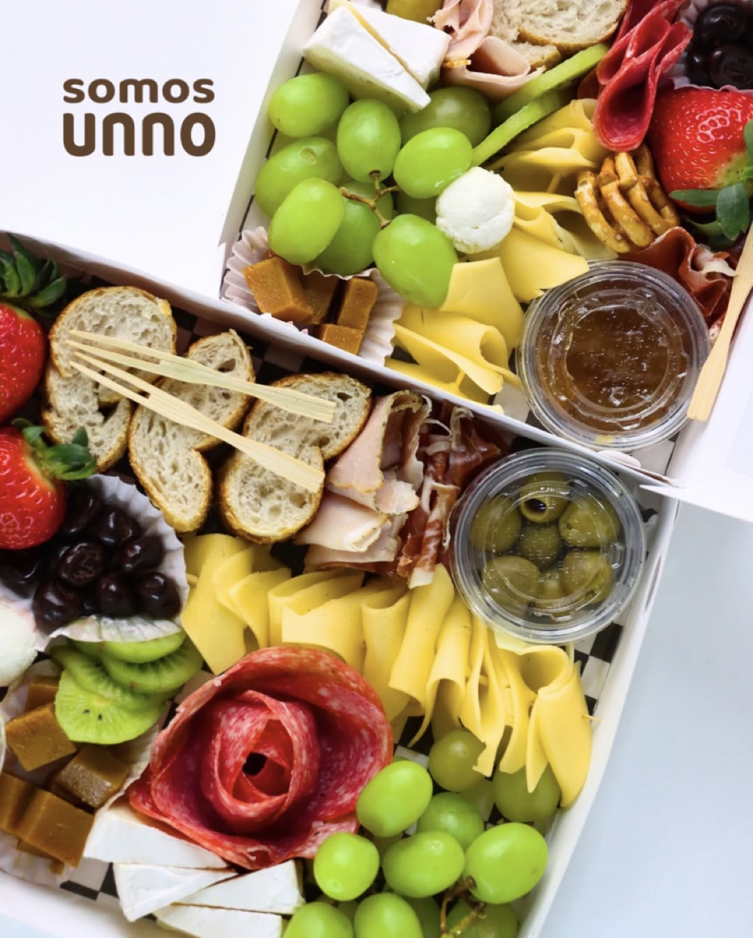 Picnic box de charcutería de Somos Unno con quesos, embutidos y fruta — fotografía de producto por Antuario.